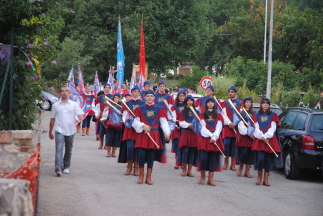 Corteo dei figuranti rosso-azzurri per le vie del paese.